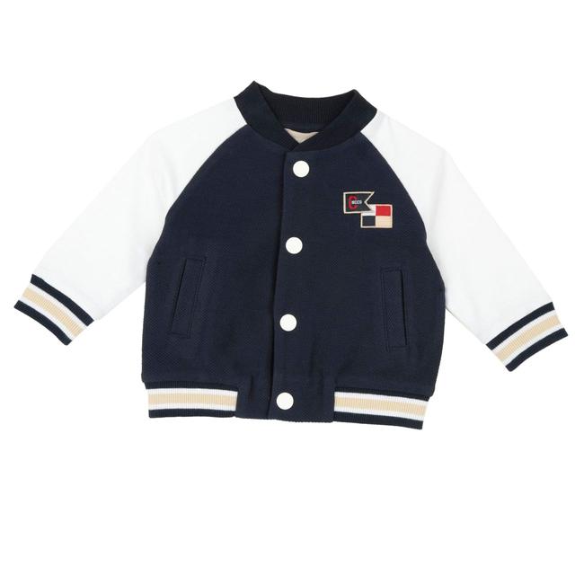 Cardigan varsity Chicco bianco in cotone sostenibile per bambino, con bottoni e dettagli a righe sui polsi e sul fondo. | Chicco